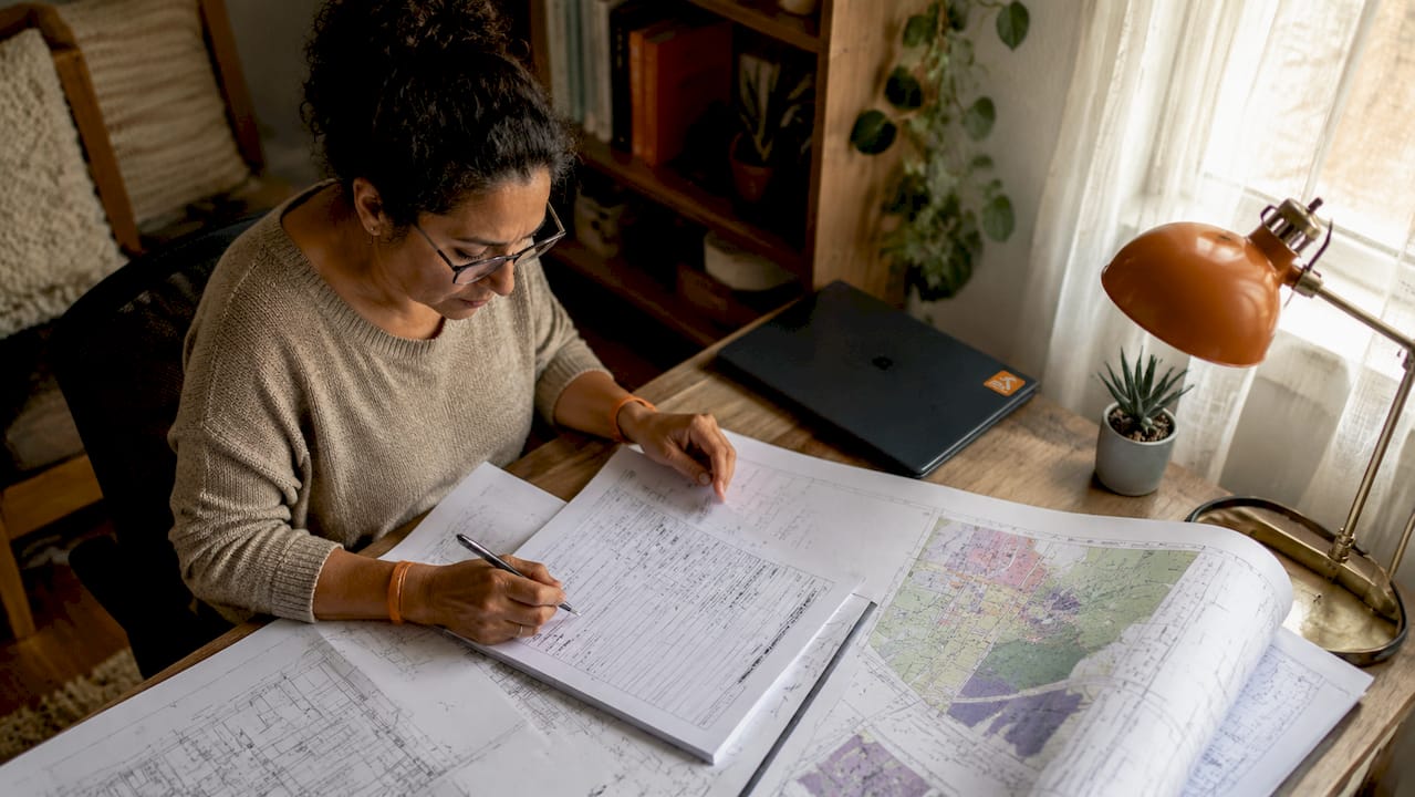 Woman filling out building permit forms at table